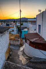 Fototapeta na wymiar Colorful evening sky over traditional greek houses in village Archangelos in Rhodes island, Greece
