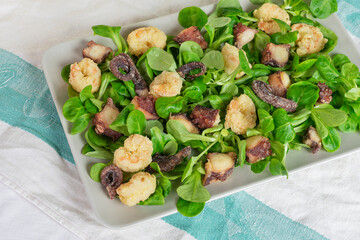 Fried octopus and shrimp on valerian salad.