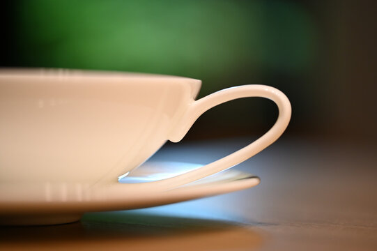 close detail handle cup of tea blurred green background
