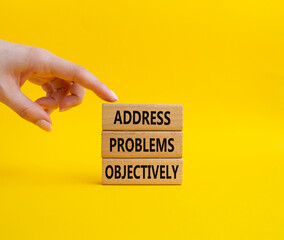 Address Problems Objectively symbol. Wooden blocks with words Address Problems Objectively. Beautiful yellow background. Businessman hand. Business and Address Problems Objectively concept. Copy space