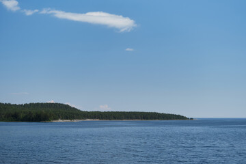 View from island Koyonsaari, Republic of Karelia on Lake Ladoga and mixed green forest in distance. Sunny warm summer day, blue sky. Concept of traveling in Russia.