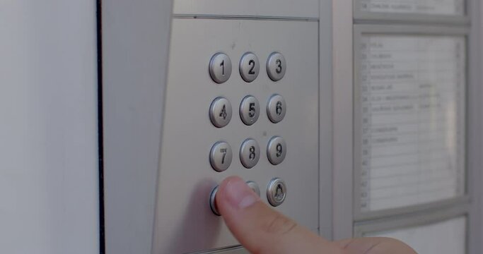 Close-up of a finger presses the intercom buttons. Remote call to the apartment to open the door. Using notifications when a guest arrives.