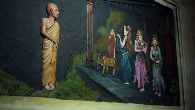 A painting on a wall in a Buddhist temple with a buddha and the history of his arrival and life