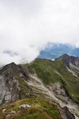 Obraz na płótnie Canvas Hiking over a misty ridge in the Alps