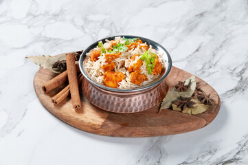 Paneer Butter Masala Biryani with raita served in a dish isolated on wooden board side view on dark background