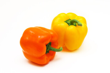 Orange and yellow peppers on a white background. Shallow depth of field
