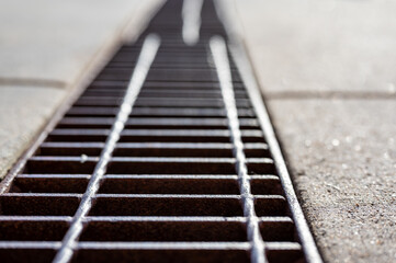 Grate over a stormwater trench in a concrete slab. 
