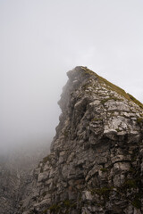 Dramatic half piece of a mountain covered by fog