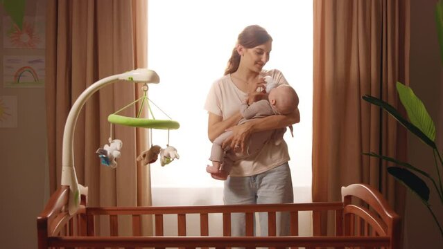 Close up young mother hold newborn baby eating from bottle. Child drink milk. Standing in apartment at home. Feel happy. Portrait. Close up. Slow motion