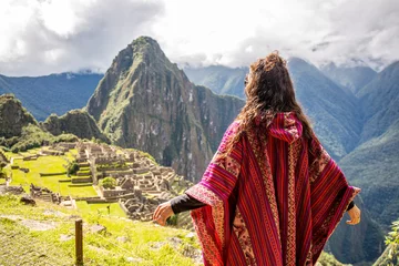 Crédence de cuisine en verre imprimé Machu Picchu Woman Looking at Inca Citadel called Machupichu built of stones on the mountain, cloudy day, Peru
