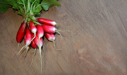 Bunch of red radishes on wood .