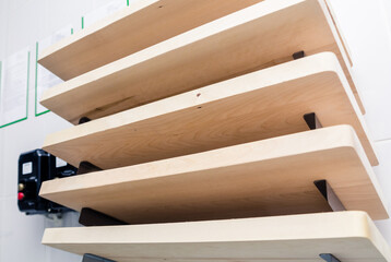 A set of wooden boards designed for cutting different types of products hangs on the wall in a professional kitchen