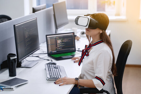 Female professional using vr virtual reality headset at desk in office