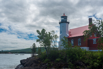 Fototapeta na wymiar Eagle Harbor Lighthouse stands above a rocky entrance to Eagle Harbor