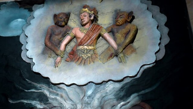 A painting on a wall in a Buddhist temple with a buddha and the history of his arrival and life