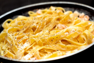 Tagliatelle pasta with shrimps in frying pan
