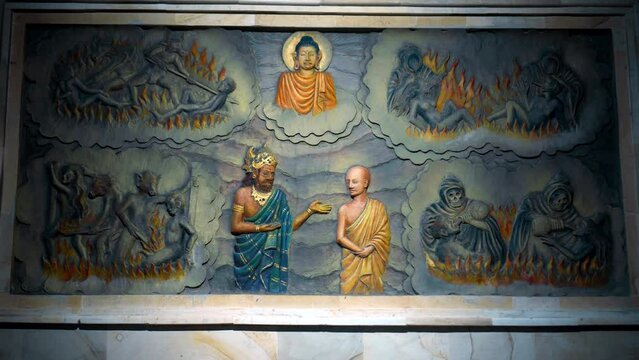 A painting on a wall in a Buddhist temple with a buddha and the history of his arrival and life. Torment of sinners. Servants of hell burn souls with fire in hell.
