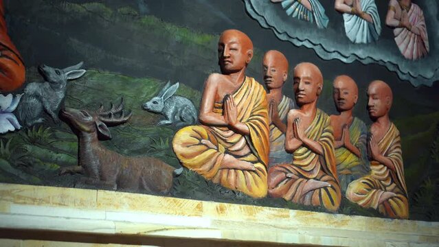 A painting on a wall in a Buddhist temple with a buddha and the history of his arrival and life