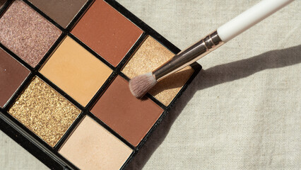 The makeup brush lies on the eyeshadow palette. Multi-colored palette of shades for makeup, face...