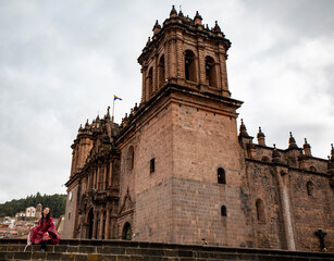 Tourist woman looking at cusco cathedral in plaza mayor, Peru