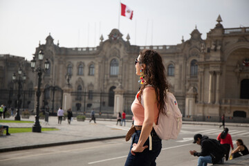 Tourist woman looking at the Government Palace of Peru, Plaza Mayor of Lima. on cloudy day