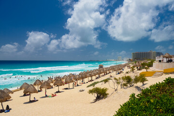 Umbrelas on a sandy beach with azure water on a sunny day near Cancun, Mexico