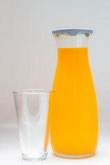 orange juice in glass cup and jug, different angles on white background