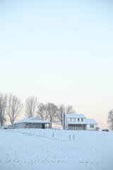 Fototapeta na wymiar Amish home on a snowy hill with trees in winter | Holmes county, Ohio