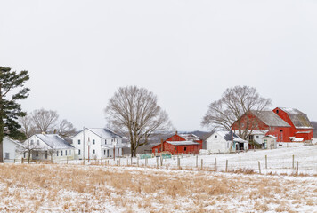Amish farm with red barns in the snowy countryside of Holmes county, Ohio