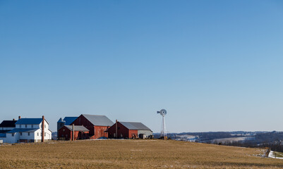 Amish farm and field on a hill in winter under a clear blue sky | Holmes County, Ohio