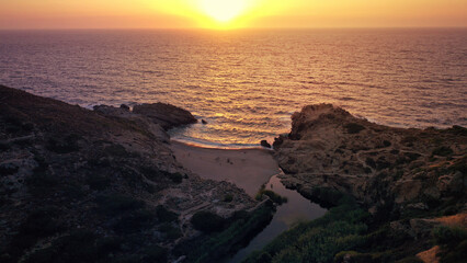 Aerial drone photo of famous breathtaking bay and sandy wavy beach of Nas with beautiful river reaching sea at sunset with beautiful reflecting colours, Ikaria island, Northeast Aegean, Greece