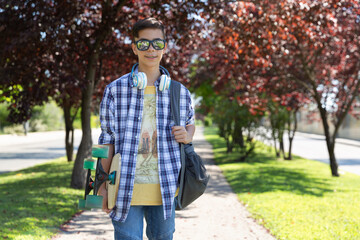 Happy teenage boy caucasian student going to high school. Outdoor portrait. Secondary education. Space for text.
