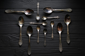 Directly above a shot of old spoons on a black table