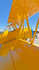 A wide angle view between the wings of a colorful biplane.