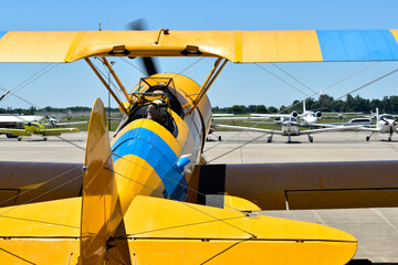 The pilot fires up the engine in a biplane in preparation for an airshow demonstration.