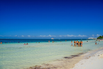 Group of people standin in the water beach on a sunny day in Cancun, Yukatan, Mexico