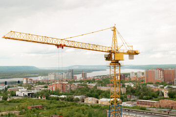 Fototapeta na wymiar tower crane top view. building background river, sunset, mountains. concept construction, new buildings, architecture and industry. construction big city against backdrop city mountains
