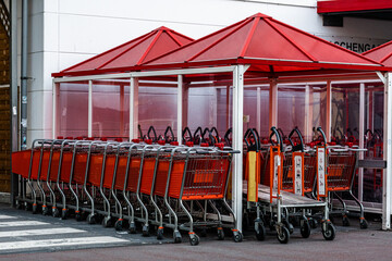 Einkaufswägen vor Baumarkt in rot mit Überstand