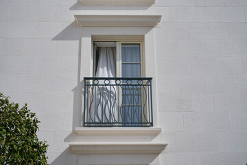 Open beige high window on Beige stone wall apartment building