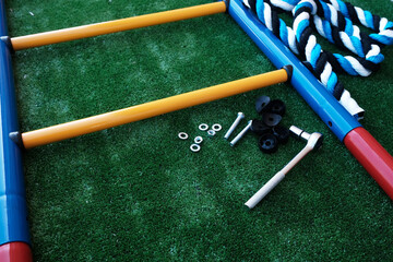 Details of a childrens sports complex, a ladder on a green background close-up, the assembly process