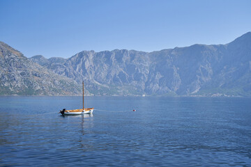 Small fishing boat in the sea against of mountains in Montenegro