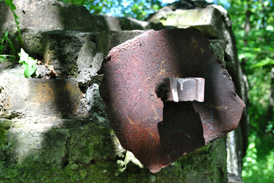Close Up of Old Iron Hinge in Part Demolished Brick Wall