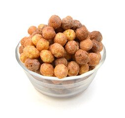 Sweeteted crunchy corn cereal made with real peanut butter and cocoa in glass bowl on white