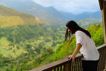 young latin long-haired man at a viewpoint in colombia Quindio, enjoying the mountainous scenery. copy space - obrazy, fototapety, plakaty