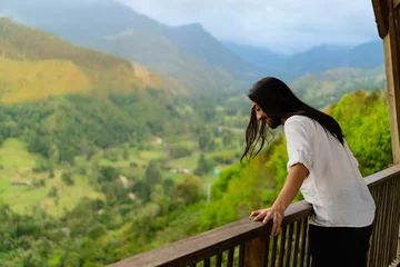 Foto op Canvas young latin long-haired man at a viewpoint in colombia Quindio, enjoying the mountainous scenery. copy space © juanpablo
