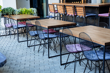 Cafe on the street interior, tables with chairs are on the sidewalk, a passage area, a place for lunch, a restaurant without people.