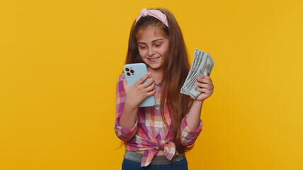 Smiling happy young child girl kid looking smartphone display sincerely rejoicing win, receiving...