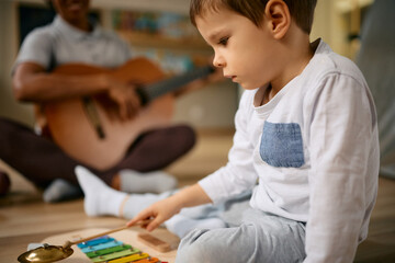 Little boy plays xylophone on music class at preschool.