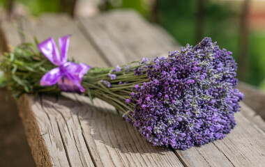 Lavender bouquet on old wooden background closeup, sunlight. Lavender flowers are used in...