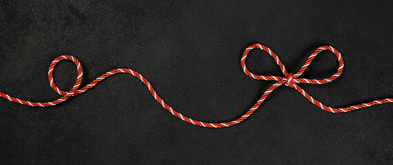 Row of red christmas ribbon on black background.